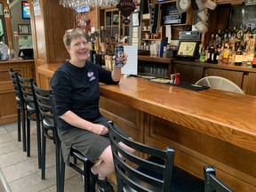 Heather Pond of the Blue Elephant Artisan Brewery in Simcoe, gets ready to celebrate with a cold beer after pulling out the bar stools over the weekend to welcome guests as capacity limits are lifted at restaurants and other establishments as of Monday.