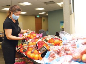 Lynne Ethier, manager of fundraising and community engagement for Our Children, Our Future, prepares bags of food for distribution to 100 families earlier this year. The initiative was a partnership with the Sudbury Food Bank.