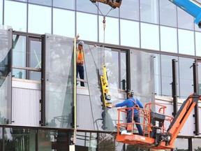 Glass panels are installed at Place des Arts in downtown Sudbury on July 27. A request has been made to the city for additional funding for the facility.