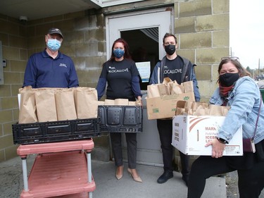 Bill Hickey, left, of the Blue Door Soup Kitchen, receives packaged lunches from Christine Stumpf, middle, Adam Killah and Laura Beaudoin, of the United Way Centraide North East Ontario, at the soup kitchen in Sudbury, Ont. on Monday. The packaged food was prepared by Apollo Restaurant as part of the United Way Local Love Lunch program. Community members can support the program by visiting uwcneo.com to purchase a ticket for a healthy meal for $15, which will go to a person in need. Participating restaurants providing meals include the Apollo, East Side Mario's and Mr. J's Roadhouse.
