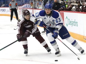 Liam Ross, right, of the Sudbury Wolves, attempts to skate past Tucker Robertson, of the Peterborough Petes, during OHL action at the Sudbury Community Arena in Sudbury, Ont. on Friday October 8, 2021. John Lappa/Sudbury Star/Postmedia Network