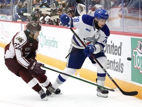 Andre Anania, right, of the Sudbury Wolves, and Tucker Robertson, of the Peterborough Petes, battle for the puck during OHL action at the Sudbury Community Arena in Sudbury, Ont. on Friday October 8, 2021. John Lappa/Sudbury Star/Postmedia Network