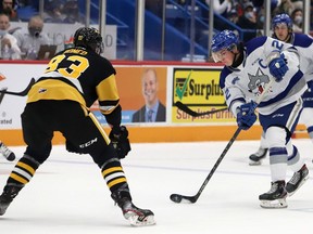 Jack Thompson, right, of the Sudbury Wolves, fires the puck past Chandler Romeo, of the Hamilton Bulldogs, during OHL action at the Sudbury Community Arena in Sudbury, Ont. on Friday October 22, 2021. John Lappa/Sudbury Star/Postmedia Network