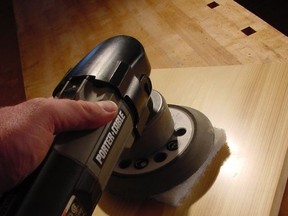 This six-inch random orbit sander used with an abrasive pad instead of sandpaper does a fabulous job at creating a mirror-like finish on wood. This sample being buffed to a high gloss has five coats of urethane. Robert Maxwell