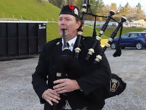 John Macdonald, of the Greater Sudbury Police Pipe Band, takes part in a flag-raising ceremony to mark the annual Poppy Campaign in Sudbury, Ont. on Friday October 29, 2021. A massive Remembrance Day flag featuring a poppy and Lest We Forget, was raised to show support for veterans and current serving members of the Canadian Armed Forces at the ceremony. John Lappa/Sudbury Star/Postmedia Network