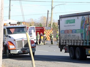Firefighters can be seen on Falconbridge Road near Goodwill Drive, across from Garson Arena in Garson, Ontario, on Friday, October 29, 2021, as traffic proceeds slowly following a collision that sent one pedestrian, a 71-year-old woman, to hospital in critical condition. Ben Leeson/The Sudbury Star/Postmedia Network