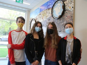 From left, Julian Smith, 13, Julia Parry, 14, Jenna Charlton, 14, and Andrea Parry, 16, stand next to the mural they helped create as students at Sarnia Christian School. It hangs in the lobby of Wellington Flats, an apartment building in Sarnia. Paul Morden/Postmedia Network