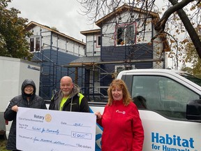 Rotary Club of Bluewaterland's Chris West (left) and Marie Watson (right) give a cheque for $5,000 to Habitat for Humanity's Serge Gauthier on Oct. 25.Handout/Sarnia This Week