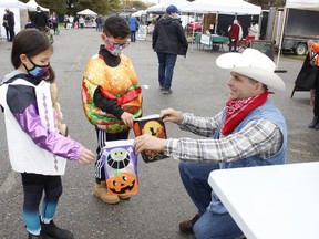 Rock Whissell, president of the Porcupine District Agricultural Society, which oversees the Mountjoy Farmers' Market, was handing out some trick-or-treat bags to Miko Tam, 10 and his sister Téa Tam, 8, as they celebrated an early Halloween at the market on Saturday. The market wraps for the season this upcoming Saturday.

RICHA BHOSALE/The Daily Press