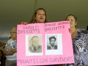 Heather Hammond, left, and her sister Janet George-Bressette hold photos of their parents who attended the former Mount Elgin Industrial Residential School at a ceremony on June 20, 2012, to unveil a monument to students who attended the school. The Chippewas of the Thames First Nation announced Sept. 30 that a team will begin searching for unmarked graves on the grounds of the former school on its territory. Derek Ruttan/Postmedia