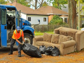 Scenes like this in downtown Simcoe have become so common that Norfolk council is discussing strategies to respond to them. Waste collectors such as Junior Richard, of Norfolk Disposal, will gather household trash so long as it is properly bagged. However, they are not equipped or contracted to deal on a weekly basis with large household waste items such as these old sofas. – Monte Sonnenberg