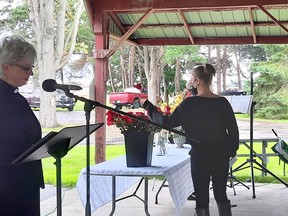 Jessica Small, recreation administer for Dutton Dunwich, lays a rose on behalf of an individual who had no one in attendance to lay the rose for them, while Rev. Diane Macpherson says the name of each person being honoured at the service. Victoria Acres photo