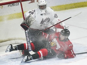 WINDSOR, ONTARIO. OCTOBER 21, 2021 - Windsor Spitfire goalie Kyle Downey gets tangled up with Servac Petrovsky of the Owen Sound Attack during their game on Thursday, October 21, 2021 at the WFCU Centre in Windsor. (Dan Janisse/The Windsor Star)