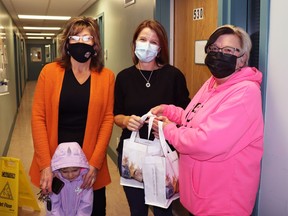 Joanne Belke and Janice Milligan presented a box of books and other goodies to Public Health Nurse Connie Adams, centre, at the homecare and community health section.