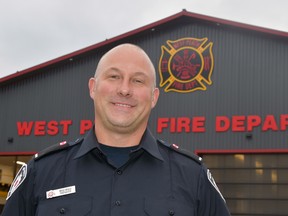 West Perth Firefighter Brad Brace stands in front of the WPFD logo he created through his business, Mitchell Ironworks. The 8-ft. by 8-ft. maltese cross was installed on Oct. 2 and essentially puts the finishing touches on the fire hall. ANDY BADER/MITCHELL ADVOCATE