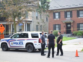 London police investigators stand outside 357 Dufferin Ave., where an officer shot a man one night prior. Photo taken on July 28, 2021. CALVI LEON / THE LONDON FREE PRESS