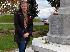 Kristen Sutherland, 21, lays white roses at the Imperial Order of the Daughters of the Empire Cross of Sacrifice cenotaph in Kingston this past week.