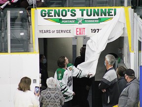 Portage Terriers' captain Logan Calder unveiling the new Geno signage at the Terriers bench. (Aaron Wilgosh/Postmedia)