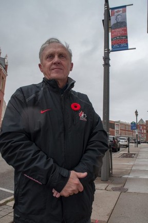 John Kastner, general manager of the Stratford Perth Museum, next to the Remembrance Day banner recognizing his father, Howard Kastner.