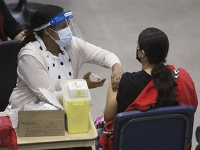 A nurse delivers a COVID-19 vaccination shot at the First Nations Vaccination Clinic at the River Cree Resort and Casino, near Edmonton Tuesday April 13, 2021. On Monday, Nov. 8, COVID-19 vaccine boosters were made available to certain demographics in Alberta. DAVID BLOOM /Postmedia File