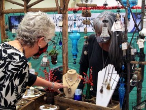 Gisele Reinboldt looks at some of the hand-crafted jewelry made by Aline Coote, Saturday, at the 32nd Artisans Craft Show at the Davedi Club.
PJ Wilson/The Nugget