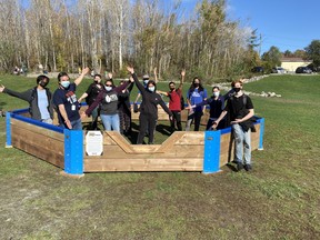 Grade 11/12 students taking a construction technology class at Sudbury Secondary School celebrate the completion of a gaga ball pit they built for elementary students at Princess Anne Public School.
