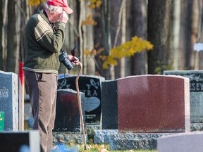 Christopher Petrie wipes a tear from his eye as he is overcome with emotion as he walks along the rows of defaced monuments at Elmwood Cemetery Tuesday in Belleville, Ontario. ALEX FILIPE