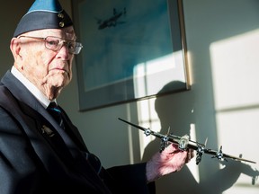 Canadian war veteran Lieut. Bill Robertson holds a model airplane of the bomber he used to fly in during the Second World War. Robertson celebrated his 100th birthday this past summer. in Belleville, Ontario. ALEX FILIPE