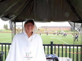 Wearing his Pyeongchang 2018 poncho on a drizzly afternoon, Randy Pascal keeps score during a flag football game at James Jerome Sports Complex in Sudbury, Ontario.