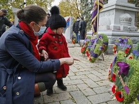 Belleville's Lisa Fleury explains wreaths to her one-year-old daughter, Sarah Fleury, after a Remembrance Day service Thursday in Memorial Park. Both of Lisa's grandfathers served in the Second World War; her father also flew with the Royal Air Force.