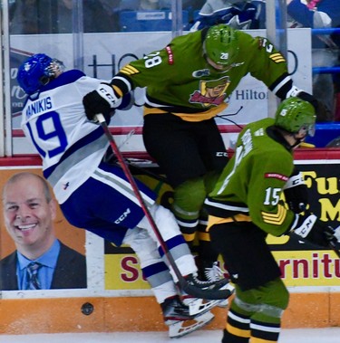 Alexander Lukin of the visiting North Bay Battalion checks Kosta Manikis of the Sudbury Wolves in the second period of their Ontario Hockey League game Friday night. Manikis was taken off the ice on a gurney, but there was no penalty on the play for the clean check.
Sean Ryan Photo