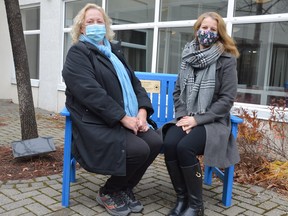 Finnish Language School vice-chair Norma Rautiainen, left, and chair Nina Maki try out the new bench that the school installed at Finlandia Village in connection with its 50th anniversary.
