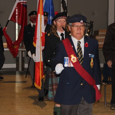 Sgt. at Arms Fred White leads the colour party into the ceremony.