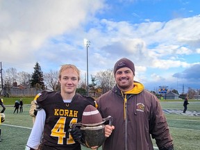 Korah Colts linebacker and tight end Nathan Keranen and Colts head coach Tom Annett with the  Northern Ontario Secondary School Athletics trophy following their 37-0 victory over the Algonquin Bears on Saturday afternoon at Superior Heights.