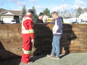 Volunteers erect new boards at an outdoor rink on Gordon Street, on the outskirts of Garson.