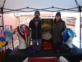 Darryl and Kelsy Gyarmati display some of the hand-knitted toques and scarves at the kickoff fundraising event for their goal of pursuing in vitro fertilization (IVF) on November 20.