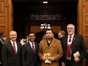 Todd Decker (left), clerk of the Ontario legislature, Yasir Naqvi, former Ontario Attorney General and now MP for Ottawa Centre, artist Garrett Nahdee, Walpole Island First Nation, and Dave Levac, former Brantford-Brant MPP and Speaker of legislature, at the unveiling of a wood carving added to the Ontario legislative chamber. Photo by Nokomis O’Brien