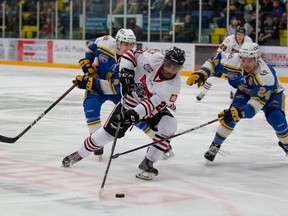 Fort McMurray Oil Barons  defenseman Lucas Jones tried to take the puck from the Whitecourt Wolverines. Photo by Dan Lines