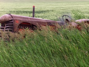 An old Massey Harris tractor sits in a farmer's field.