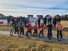 The Rotary Club of High River donated $30,000 towards the High River Pump Track during a cheque presentation on Nov. 20, right in front of the future pump track location. Rotary members (back-left), along with parents and pump track committee members (back-right) and kids (front) took part in presentation.