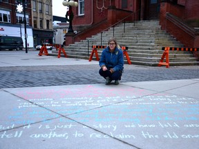 Jenn Mezei, a member of the new environmental advocacy and activism group, the Perth County Sustainability Hub, chalked a quote about the commoditization of natural resources from Indigenous scientist, professor and author Robin Wall Kimmerer’s book, Braiding Sweetgrass, in front of Stratford city hall Saturday evening. Galen Simmons/The Beacon Herald/Postmedia Network