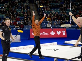 Skip Brad Gushue raises his arms after defeating Brad Jacobs 4-3, to capture the men's curling trials in Saskatoon on Sunday night.