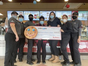 Riseup Society Alberta executive director Ryley Miller accepted a cheque for $6,584, proceeds from the Smile Cookie campaign at four local Tim Hortons locations. (Riseup Society Alberta)