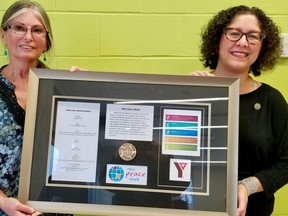 YMCA 2021 Peace Medal winners Susan Staves, left, and Aly Boltman have their names added to the Y's commemorative display of past Peace Medal winners, whic they're holding on Thursday, Nov. 18, 2021 in Owen Sound, Ont. (Scott Dunn/The Sun Times/Postmedia Network)