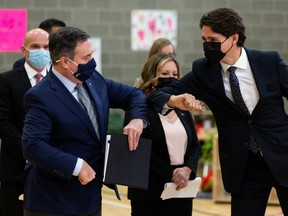 Prime Minister Justin Trudeau (right) and Alberta Premier Jason Kenney bump elbows during a joint federal-provincial announcement of $10-a-day daycare at Boyle Street Plaza in Edmonton, on Monday, Nov. 15, 2021. Photo by Ian Kucerak
