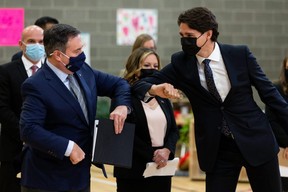 Prime Minister Justin Trudeau (right) and Alberta Premier Jason Kenney bump elbows during a joint federal-provincial announcement of $10-a-day daycare at Boyle Street Plaza in Edmonton, on Monday, Nov. 15, 2021. Photo by Ian Kucerak
