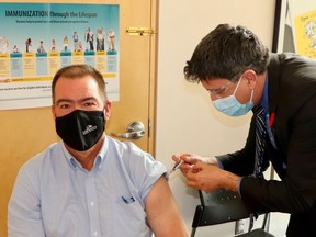 Brian Milne gets the flu shot from Dr. Ian Arra, the medical officer of health in Grey-Bruce on Monday, Nov. 15, 2021 in Owen Sound, Ont. Milne is the deputy mayor in Southgate and is a board of health director. (Supplied photo)