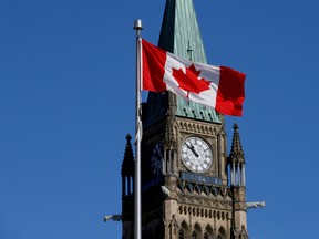 A Canadian flag flies in front of the Peace Tower on Parliament Hill in Ottawa.