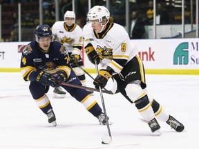 Sarnia Sting's Nolan Dann (9) is defended by Erie Otters' Noah Sedore (74) in the second period at Progressive Auto Sales Arena in Sarnia, Ont., on Sunday, Nov. 7, 2021. Mark Malone/Chatham Daily News/Postmedia Network