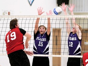 Chatham Christian Flames' Evan VanMinnen (15) and Grady Vellinga (12) try to block Lambton-Kent Cardinals' Griffin Kelly (19) during the LKSSAA senior boys' volleyball A final at Chatham Christian High School in Chatham, Ont., on Wednesday, Nov. 17, 2021. Mark Malone/Chatham Daily News/Postmedia Network